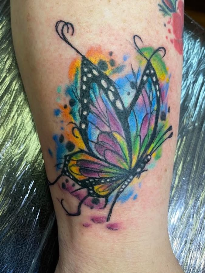a colorful butterfly with a watercolor splash like style underneath