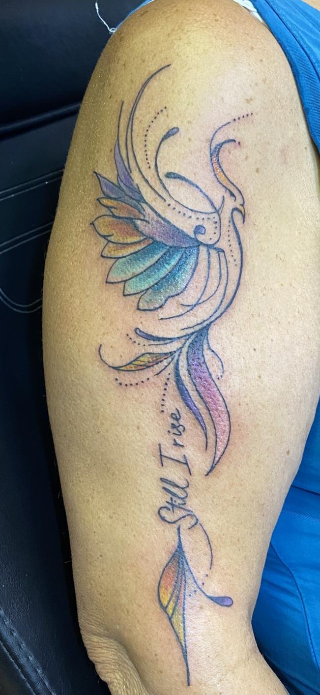 a fine line abstract flying bird with it's feathers and tail feathers done in pastel colors, the tattoo has a very swirly effect