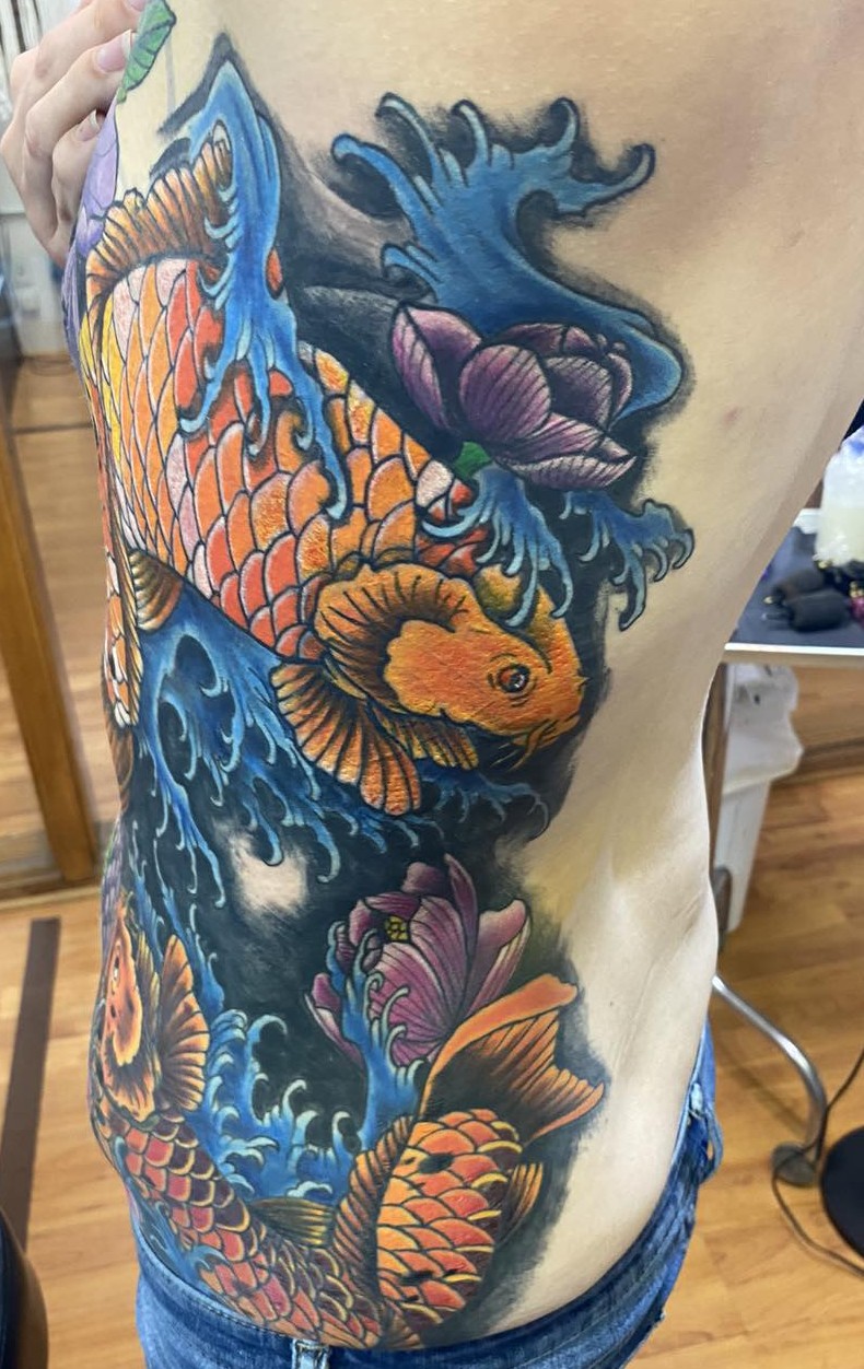 a full side piece in color with orange coy fish swimming through waves and large purple flowers